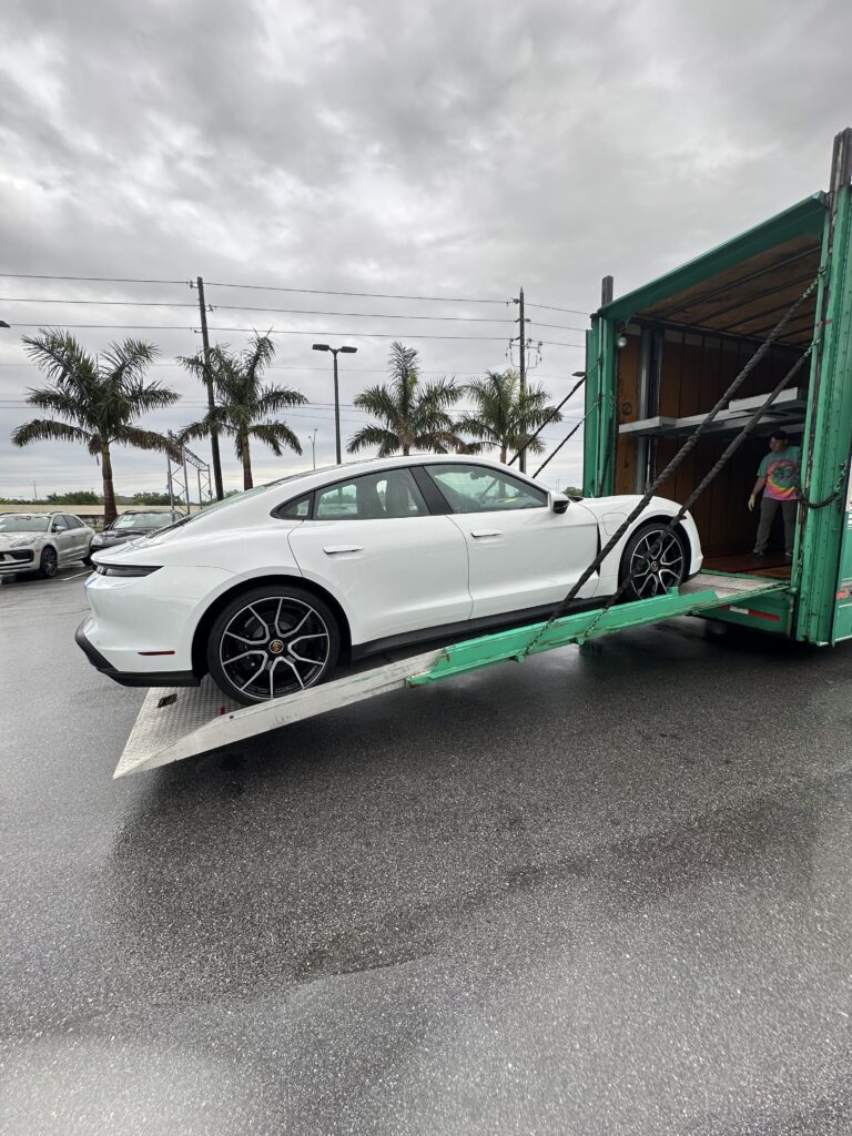 Car being loaded for transport into the back of an enclosed trailer.