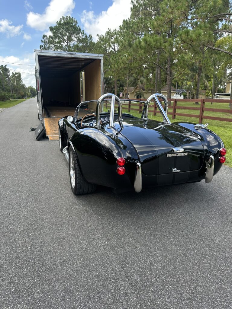 Collector Car being loaded into the back of an enclosed transport trailer.
