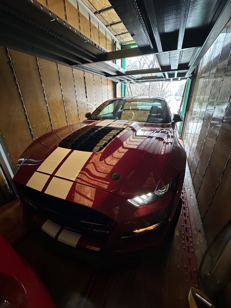 Can loaded into an enclosed trailer being secured for transport.