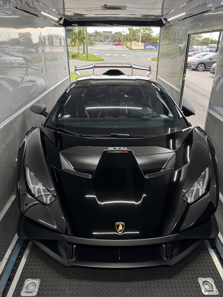 Lamborghini loaded into the back of an enclosed trailer ready for transport.