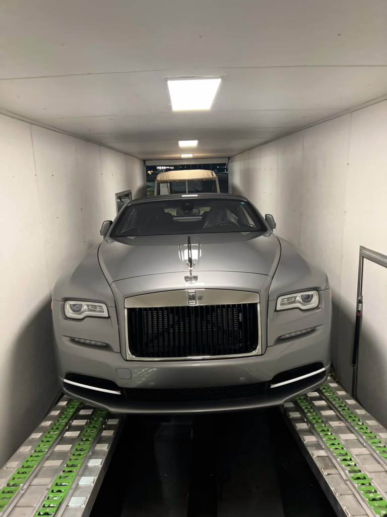 Rolls-Royce loaded in the back of an enclosed transport trailer.